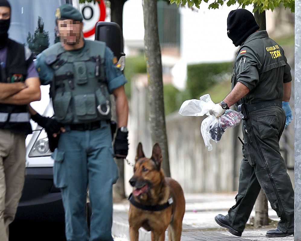 Un agente se deja guiar por un perro adiestrado para la localización de explosivos.