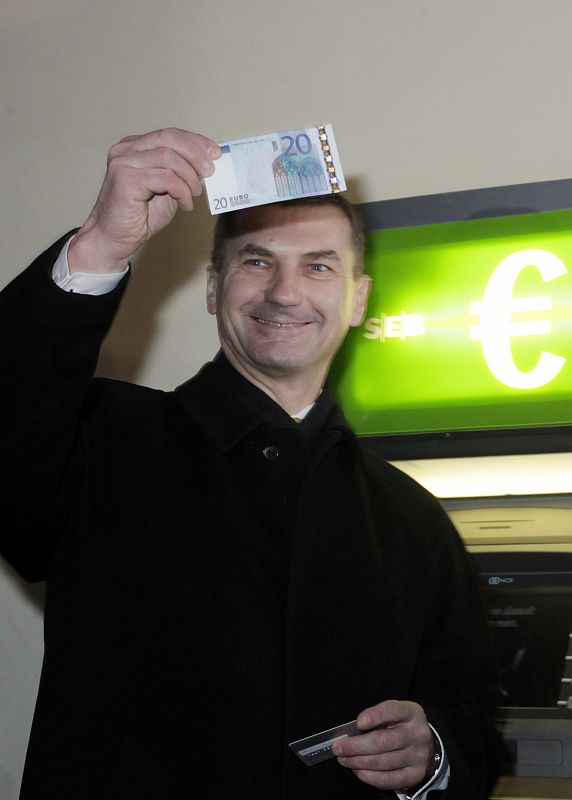 Andrus Ansip, primer ministro de Estonia, muestra orgulloso el billete de 20 euros que ha sacado de un cajero de Tallin