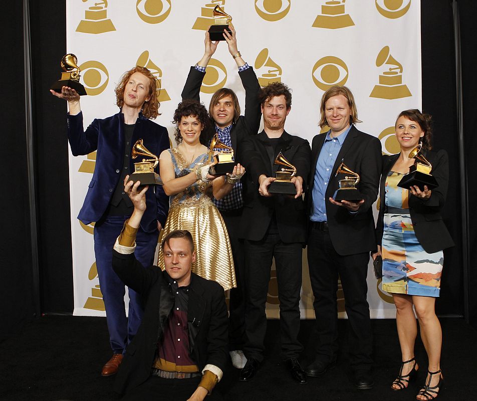 Members of the Canadian band Arcade Fire including lead singer Win Butler, seated front, pose with their Album of the Year awards for the album "The Suburbs" at the 53rd annual Grammy Awards in Los Angeles, California