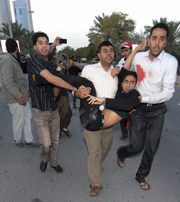 Un grupo de manifestantes traslada a un herido por los disparos de las fuerzas de seguridad