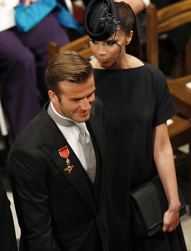 Victoria Beckham ha lucido un sobrio vestido negro y un original tocado en el mismo tono.
