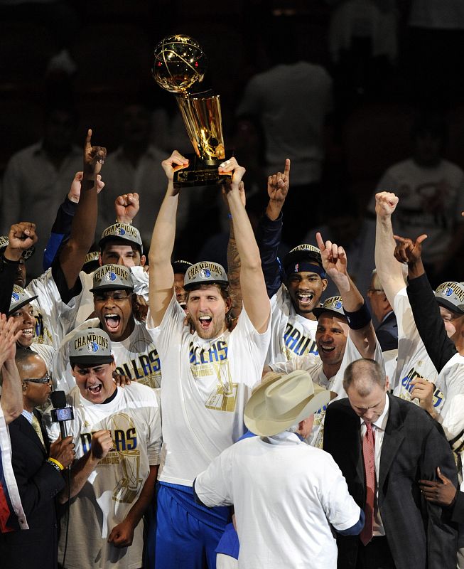 El jugador de los Mavericks de Dallas Dirk Nowitzki (c) sostiene el trofeo tras ganar la final de la NBA ante los Heat de Miami el domingo 12 de junio de 2011 en el American Airlines Arena en Miami, Florida (EEUU). Los Mavericks se coronaron campeone