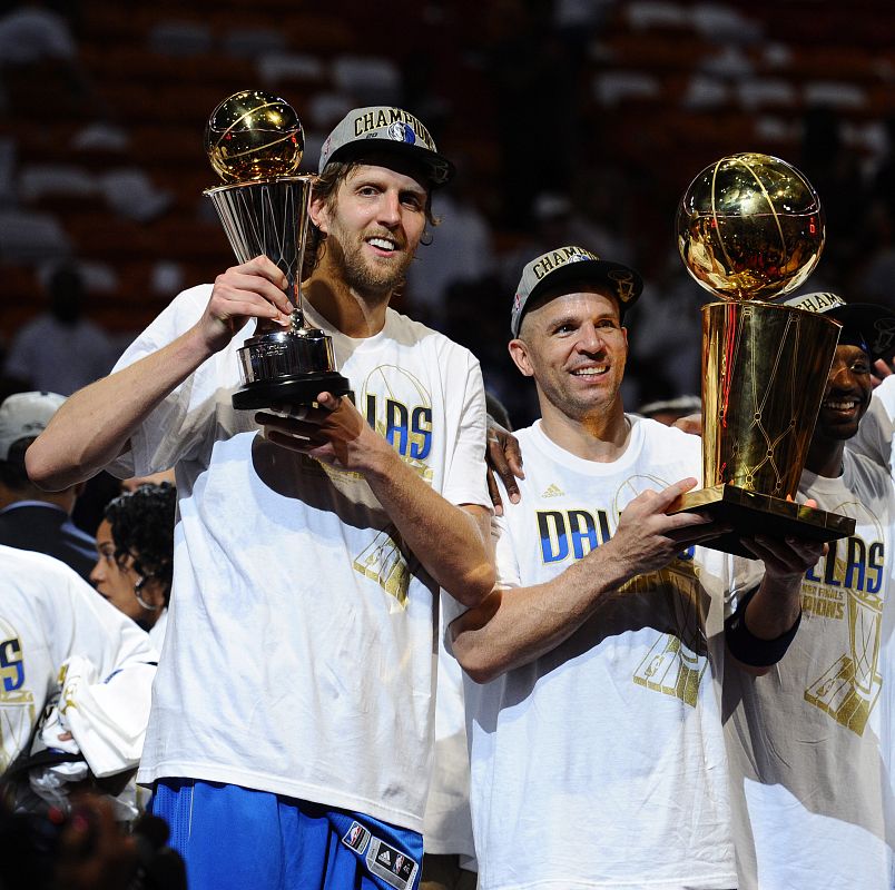 El jugador de los Mavericks de Dallas Jason Kidd (d) sostiene el trofeo de la NBA, mientras su compañero Dirk Nowitzki (i) alza el de Jugador Más Valioso tras ganar la final de la NBA ante los Heat de Miami