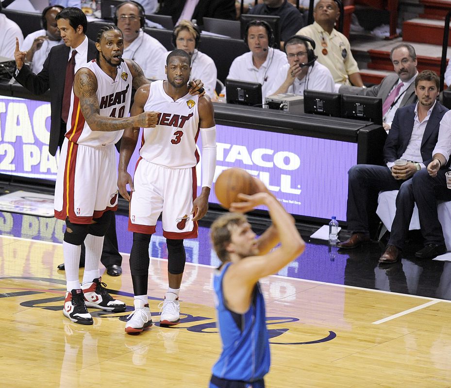 El jugador Dirk Nowitzki (dcha) de los Mavericks de Dallas lanza un tiro libre ante la atenta mirada de Udonis Haslem (izda) y Dwyane Wade (centro) de los Heat de Miami
