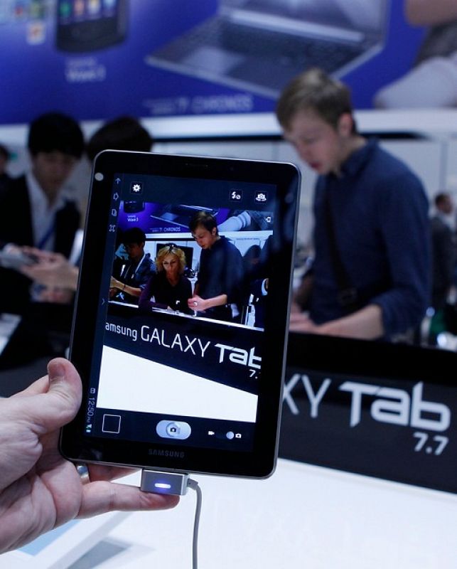 Uno de los visitantes de la feria tecnológica de Berlín (IFA) sostiene la nueva tableta de Samsung, la Galaxy Tab 7.7, que solo pesa 335 gramos