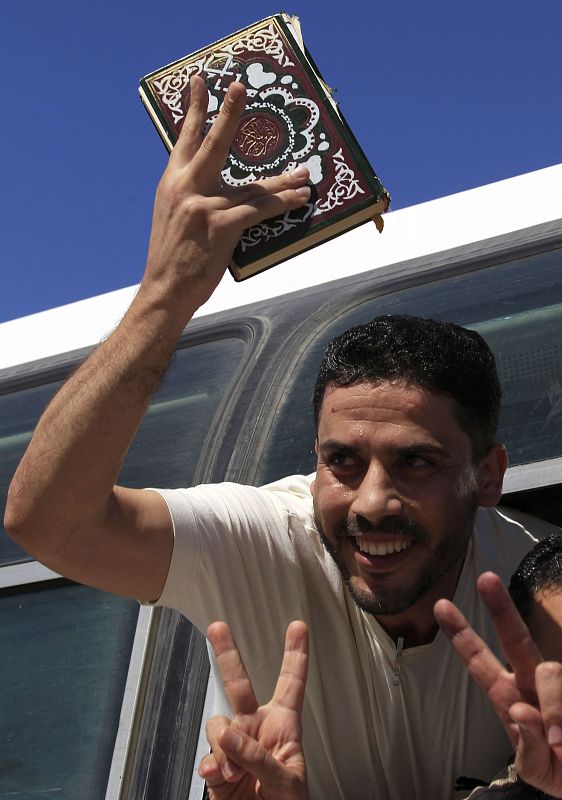 Un preso palestino excarcelado por Israel sostiene un Corán en el autobús que cruza la frontera entre Gaza y Egipto