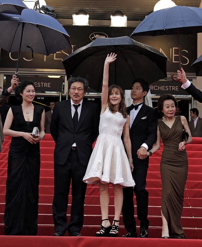 Director Hong Sangsoo arrives on the red carpet with cast members at the 65th Cannes Film Festival