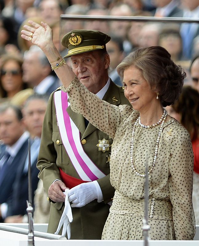 Spain's King Juan Carlos and Queen Sofia stand above the Spanish Royal seal as they preside over a military parade to mark Armed Forces Day in Valladolid