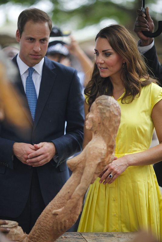 Los duques de Cambridge, durante su visita a una aldea de Honiara, en las Islas Salomón. Kate, muy favorecida y jovial con este vestido 100% algodón en color amarillo. El diseño, perteneciente a la casa Jaeger, cuesta poco más de 200 euros.