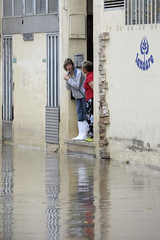 Dos mujeres observan una de las calles inundadas en la localidad navarra de Villava