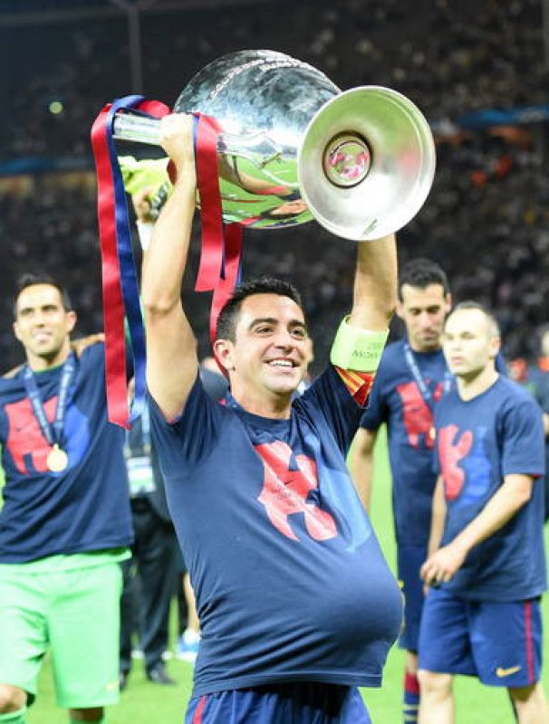 Xavi, el capitán del Barcelona, levanta la Copa de Europa con un balón metido bajo su camiseta.