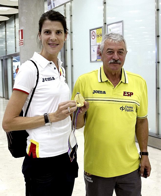 La atleta Ruth Beitia, junto a su entrenador Ramon Torralbo, muestra su medalla de oro en el aeropuerto de Barajas tras revalidar en Zúrich su título de campeona de Europa de salto en 2014.