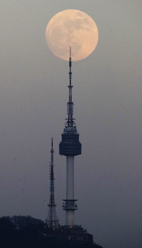 La Luna sale por detrás de la Torre N de Seúl, en el monte Nam, en Corea del Sur.