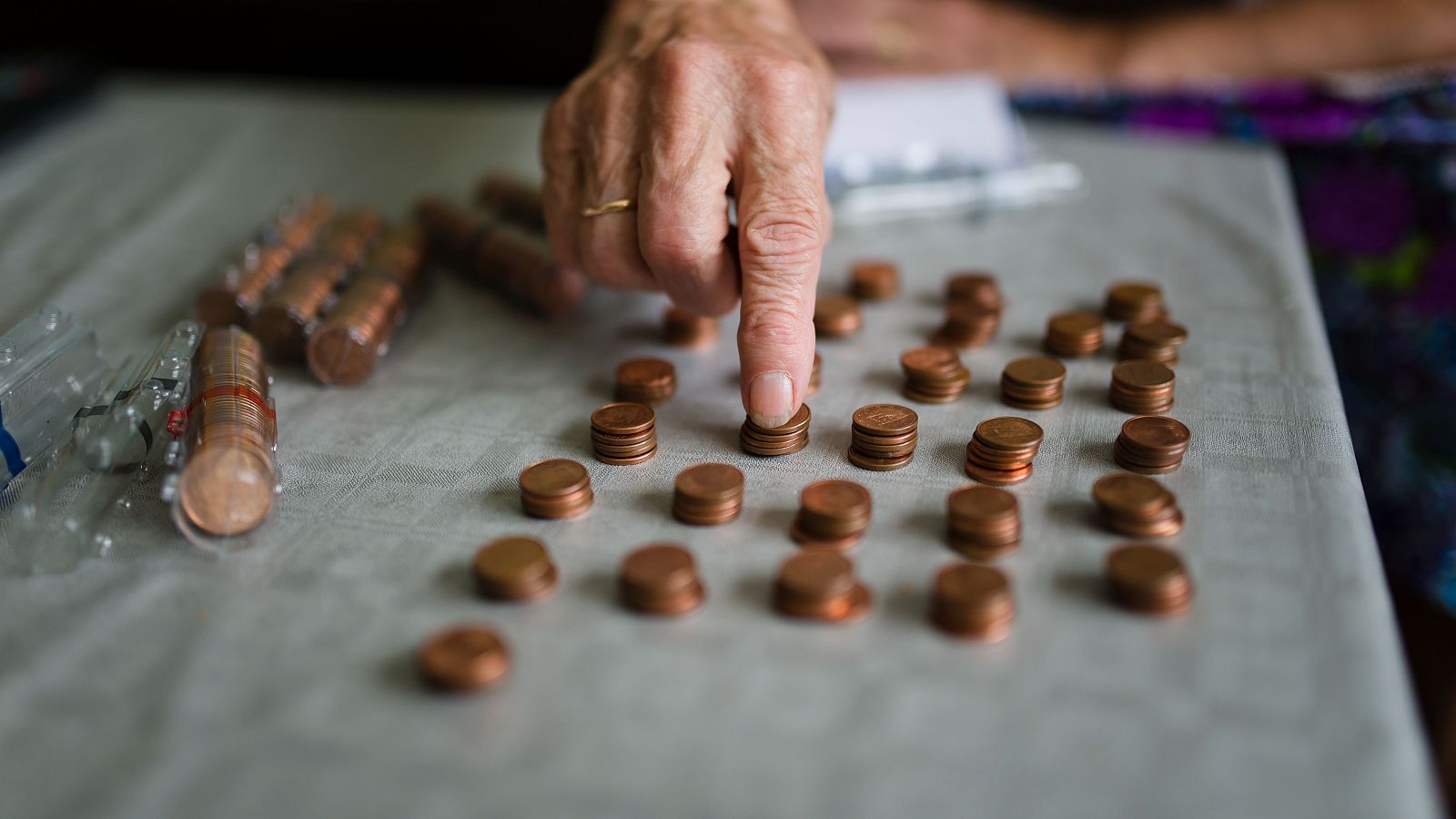 Una mujer cuenta monedas de céntimo