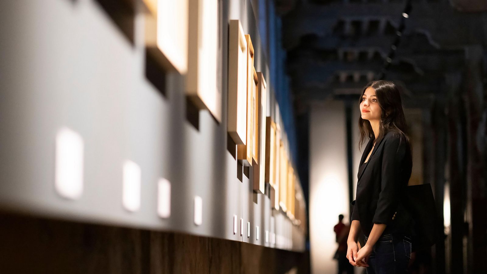 Una mujer mirando las obras de un museo