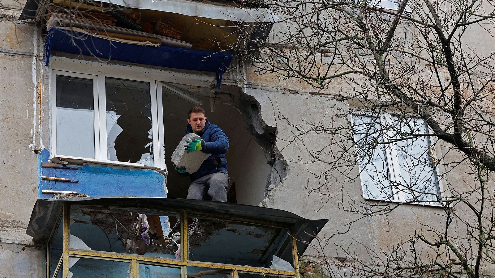 Un residente retira escombros de un apartamento dañado en un bombardeo en la ciudad de Górlovka, en la región de Donetsk