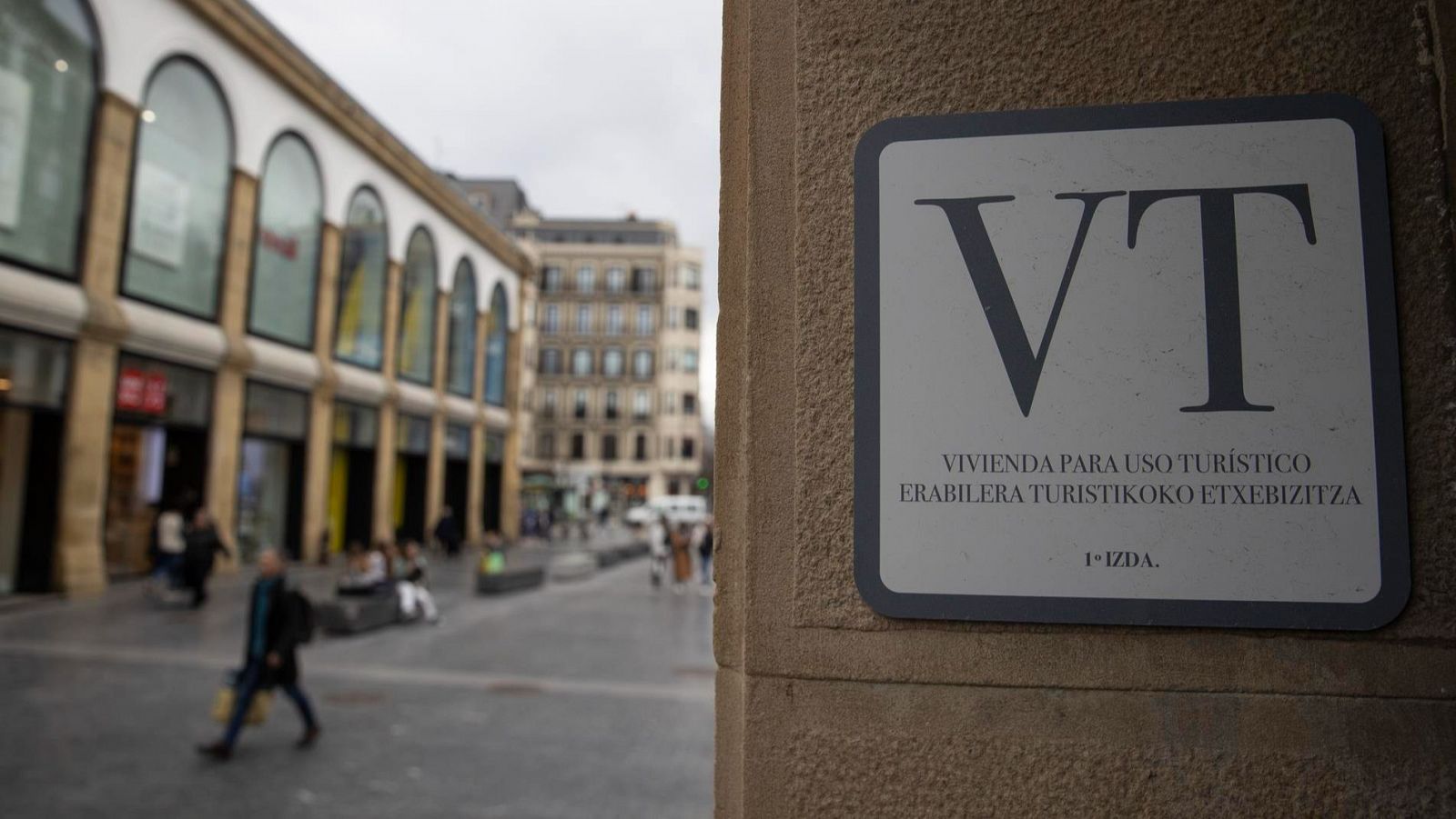 Vista de un portal con un cartel de vivienda para uso turístico en San Sebastián