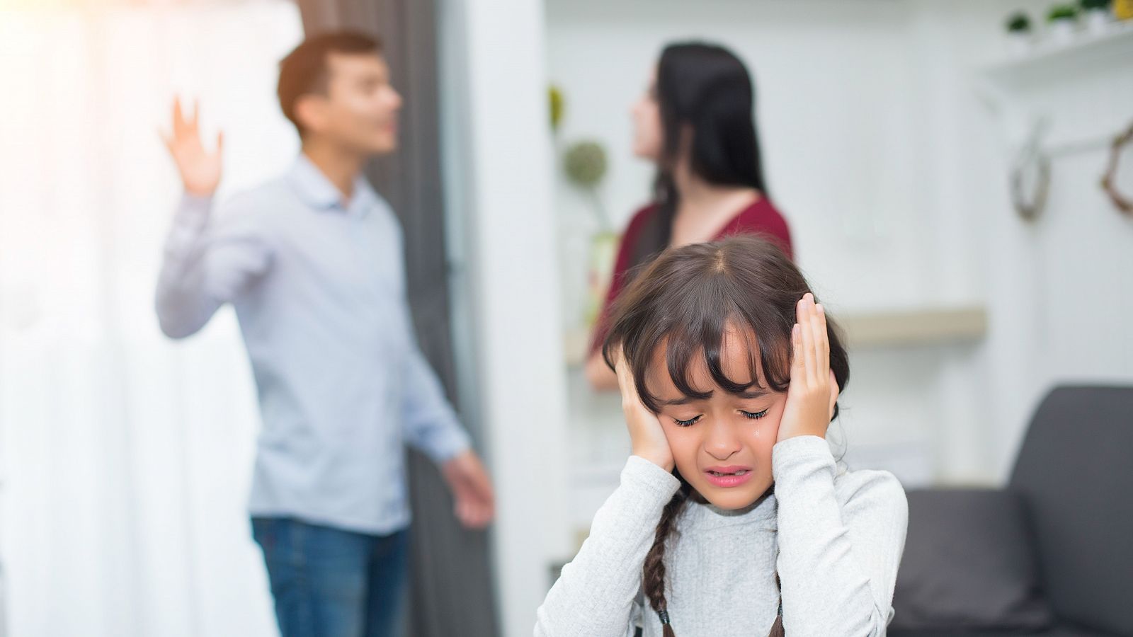 Una niña asustada durante una discusión de sus padres