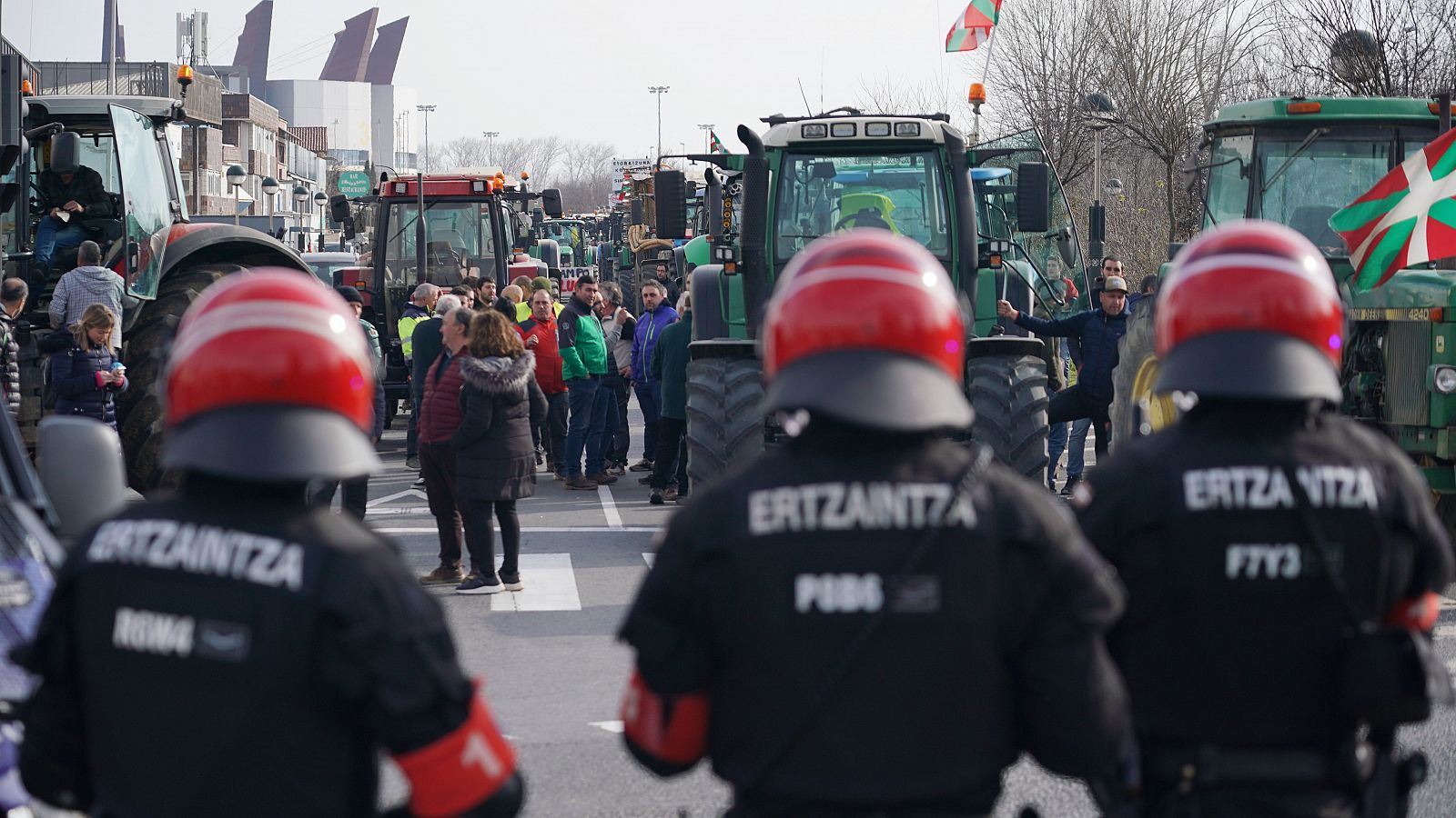 Agentes de la Ertzaintza delante de los tractores y agricultores en la segunda jornada de protestas,