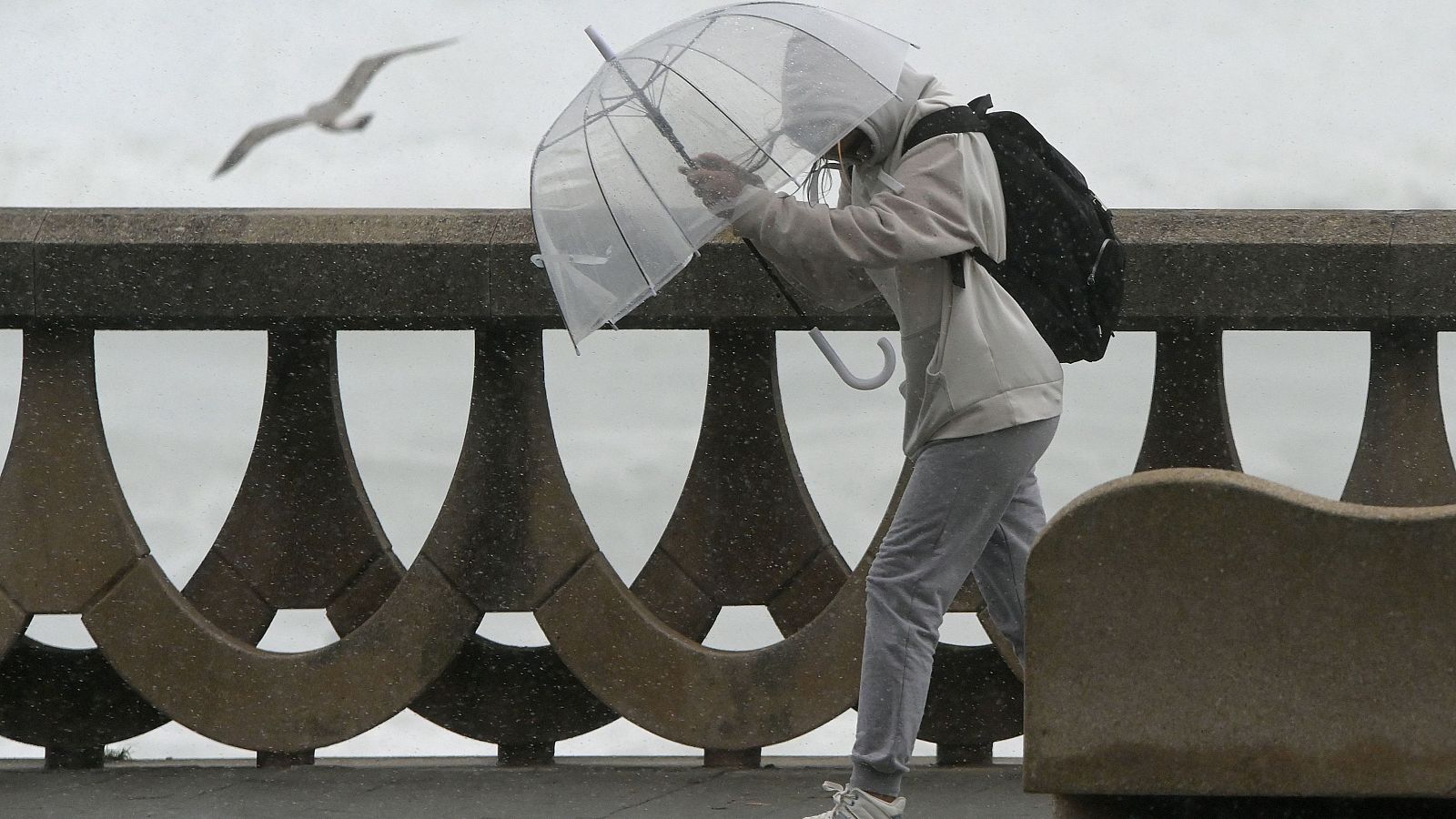 Una joven pasea bajo la lluvia y el viento por el paseo marítimo de A coruña en una imagen de archivo