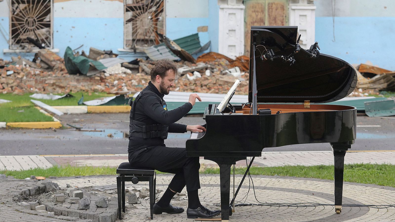 El músico lituano Darius Mazintas toca el piano frente a la Casa Central de Cultura destruida durante la invasión rusa