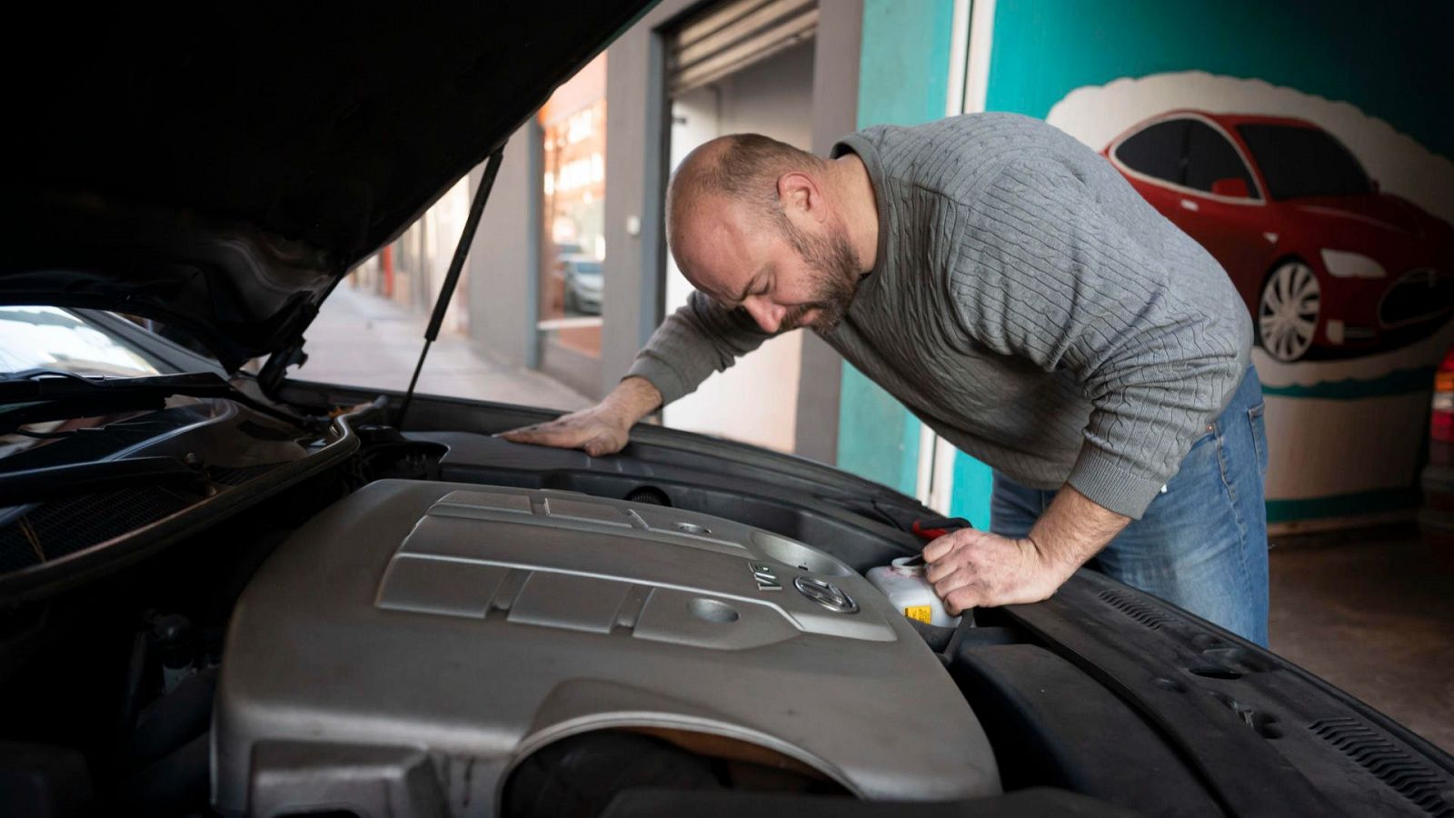 Un mecánico repara un automóvil en un taller de Santander