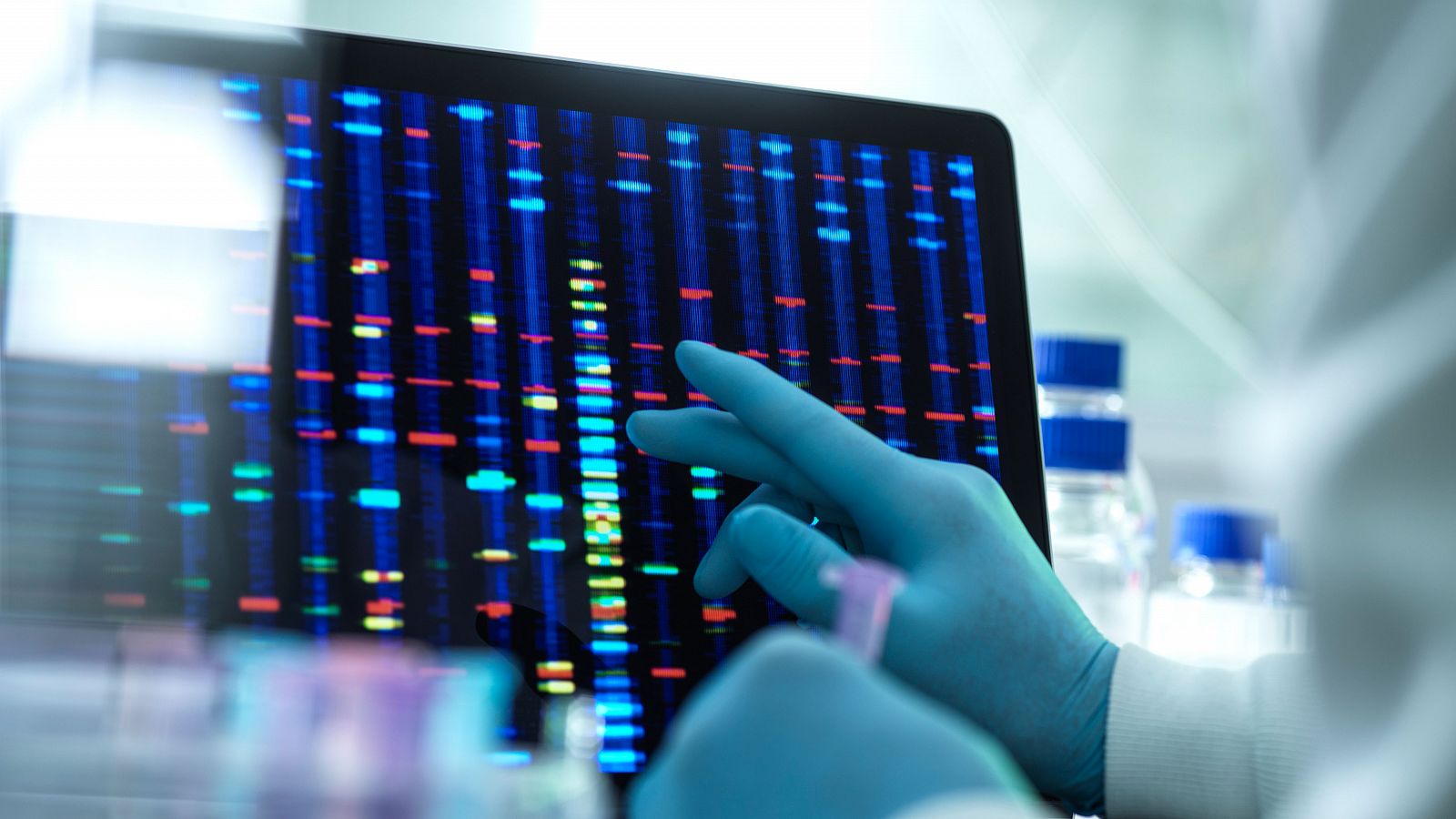 Científico investigando secuencias de ADN en una pantalla de ordenador.