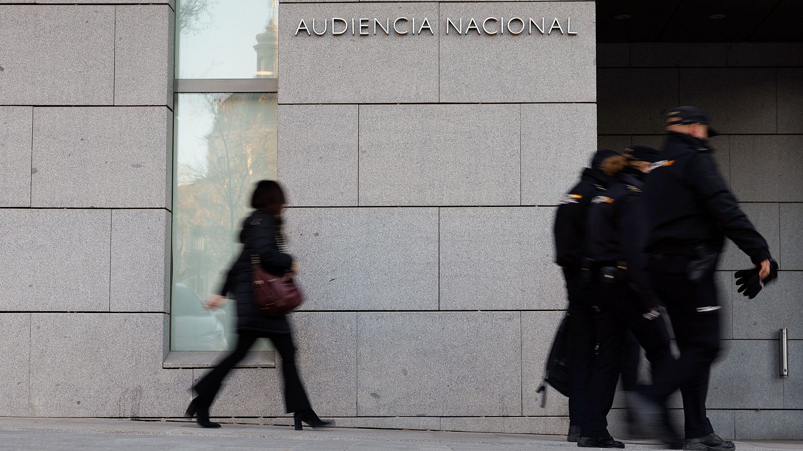 Un grupo de agentes de la Policía Nacional pasan delante de la entrada a la Audiencia Nacional