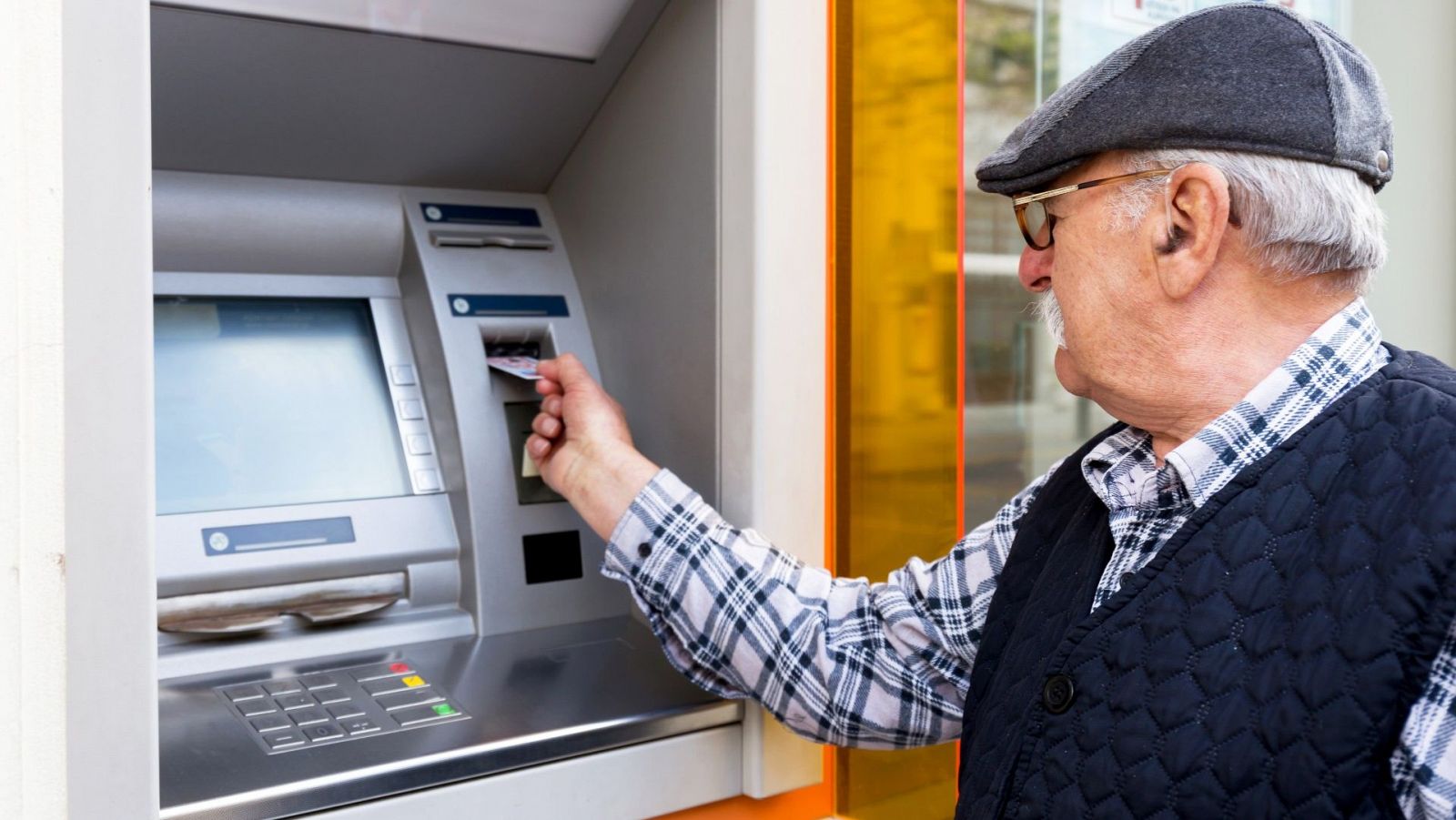 Imagen de archivo de un hombre sacando dinero de un cajero automático