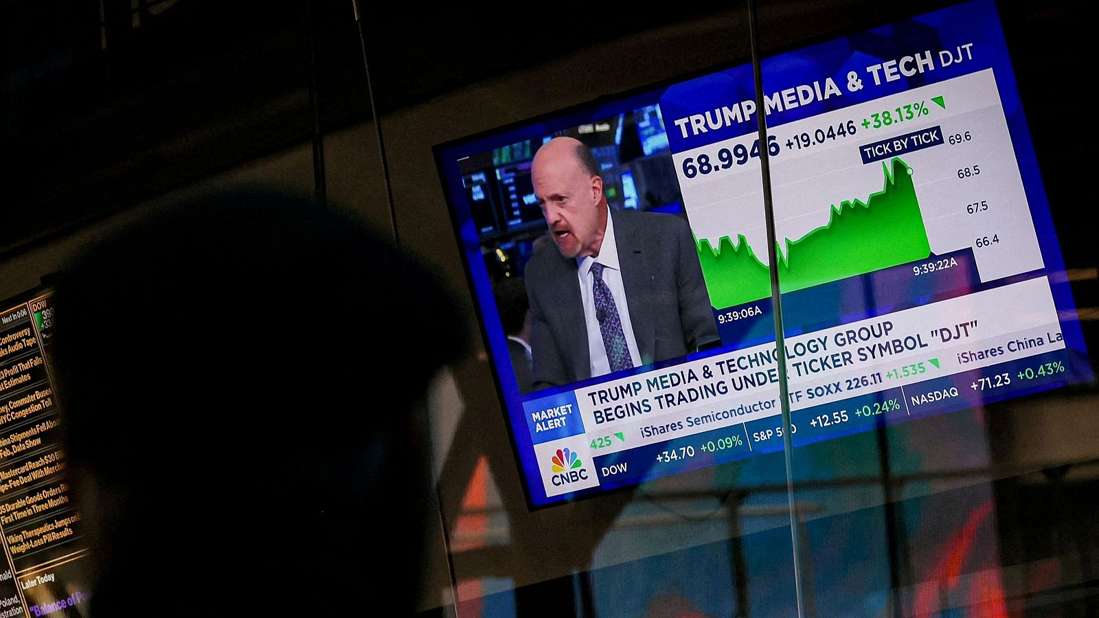 Un hombre mira una pantalla que muestra información bursátil sobre la empresa de comunicación de Trump