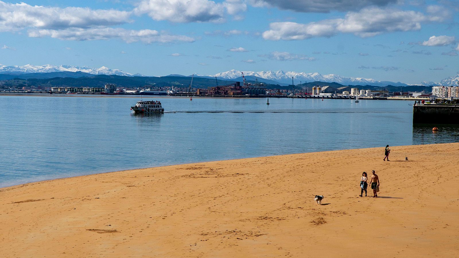 Varias personas pasean por una playa de Santander