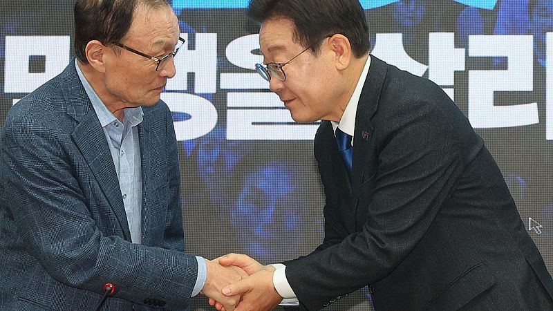 El líder del Partido Democrático, Lee Jae-myung, estrecha la mano de su jefe de campaña, Lee Hae-chan