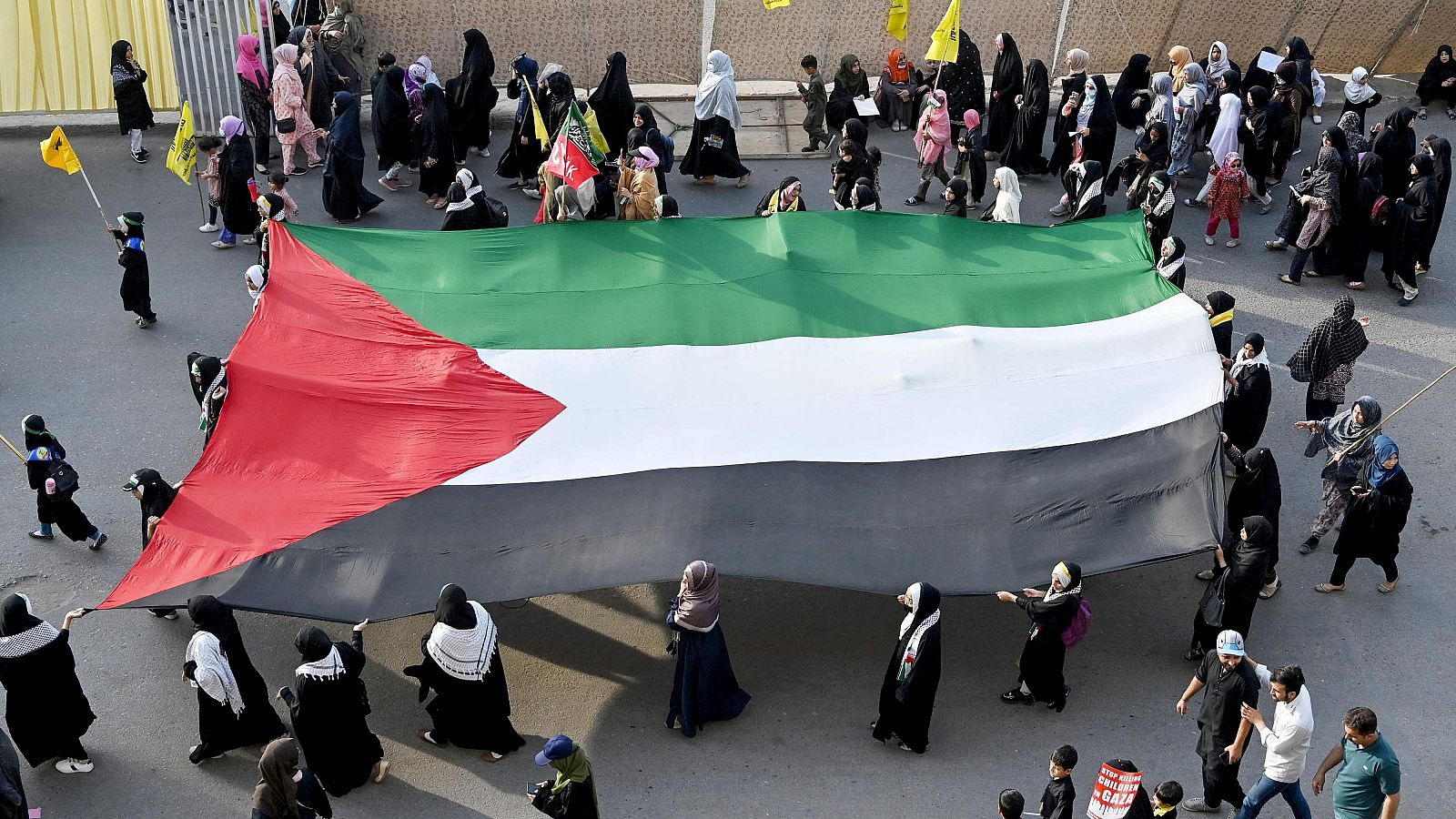 Mujeres musulmanas chiíes portan la bandera palestina durante una concentración en Karachi.