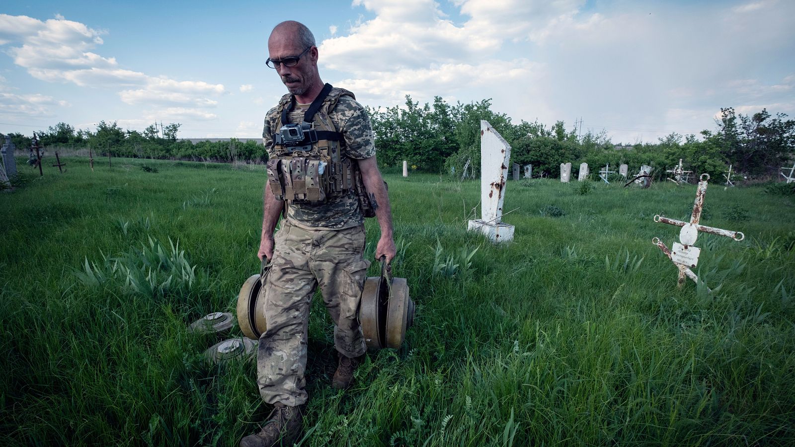 Un zapador ucraniano lleva minas después de limpiar el cementerio de la aldea de Krasnopillya
