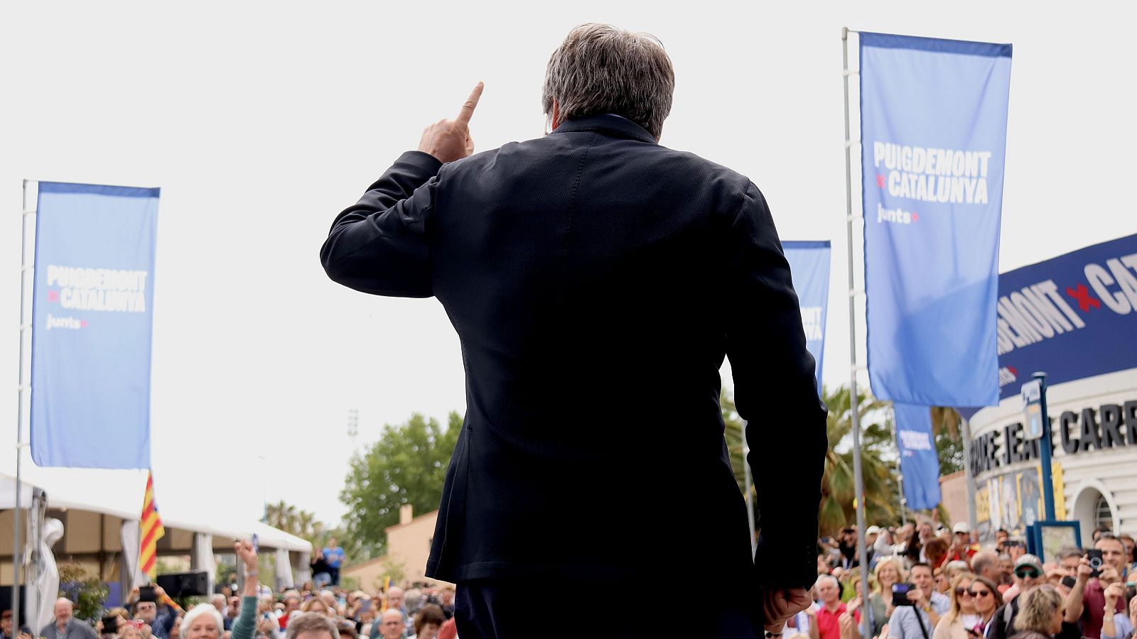 El candidat de Junts+, Carles Puigdemont, saluda el públic que segueix l'acte central de campanya d'Argelers en una pantalla a l'exterior | ACN