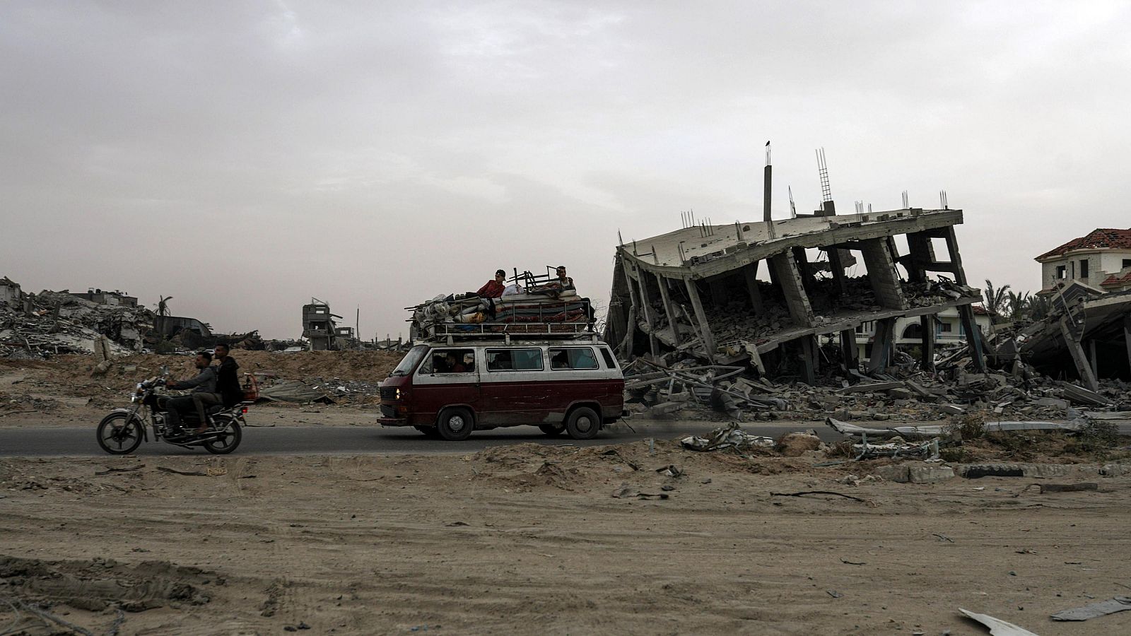 Desplazados palestinos salen con sus pertenencias tras una orden de evacuación por Israel en Rafáh.