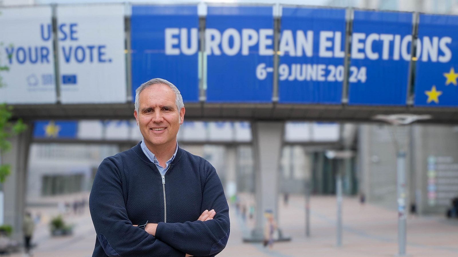 Alberto Ares posa en Bruselas delante de un cartel que anuncia las elecciones europeas de 2024.