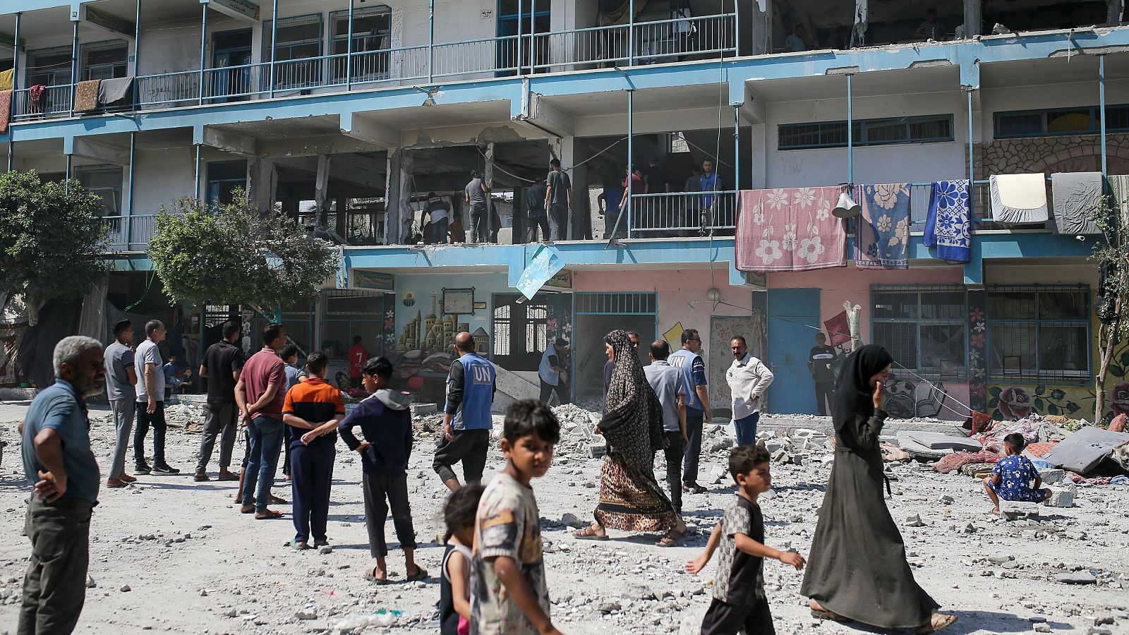 Palestinos observan la escuela de la ONU bombardeada en Nusseirat, Franja de Gaza.