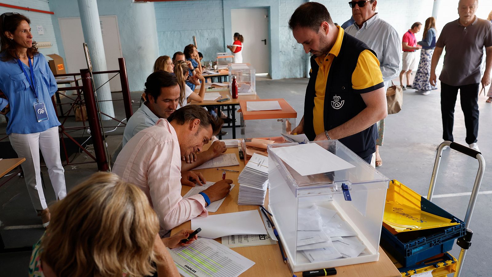 Un cartero lleva votos por correo a una de las mesas en un colegio electoral durante las elecciones generales