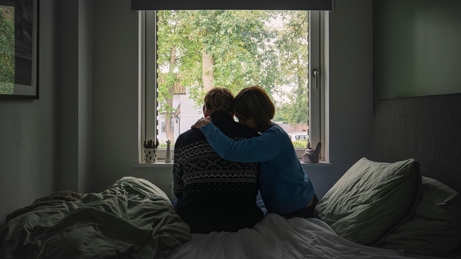 Matrimonio de espaldas frente a una ventana