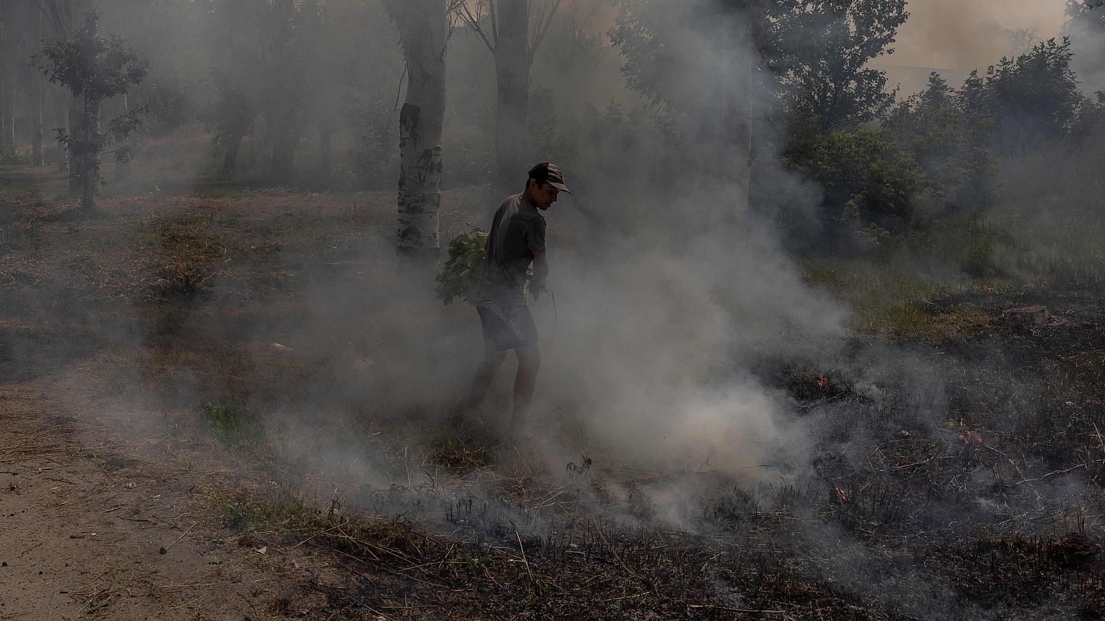 Un civil ucraniano intenta extinguir un incendio tras un bombardeo en Druzhkivka, región oriental de Donetsk