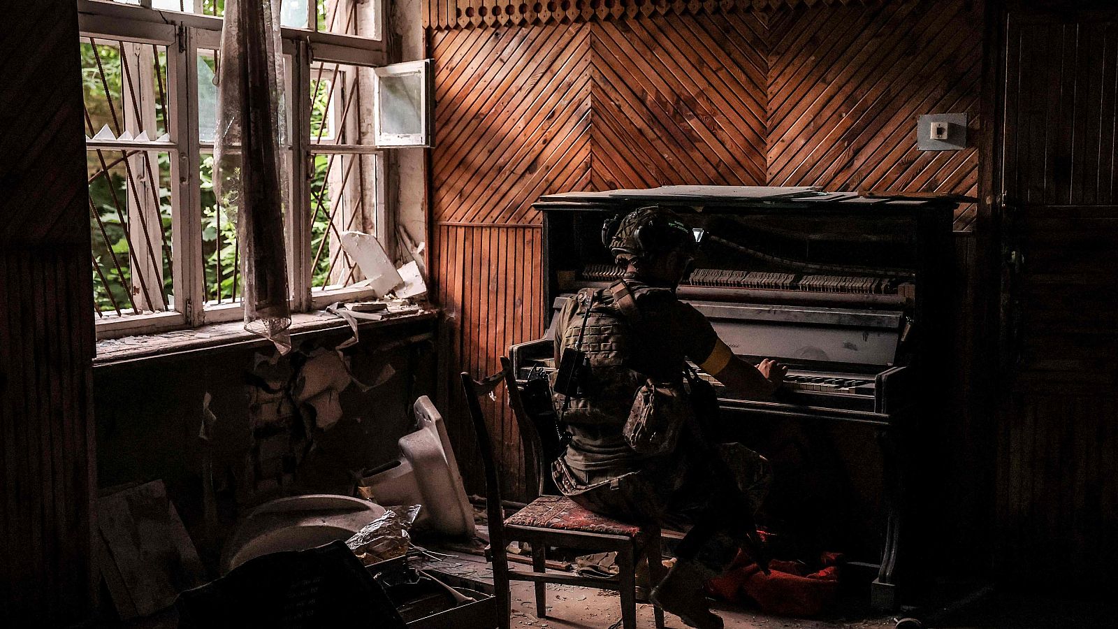 Un militar ucraniano de la 24 brigada mecanizada toca un piano dañado en un edificio en la ciudad de Chasiv Yar