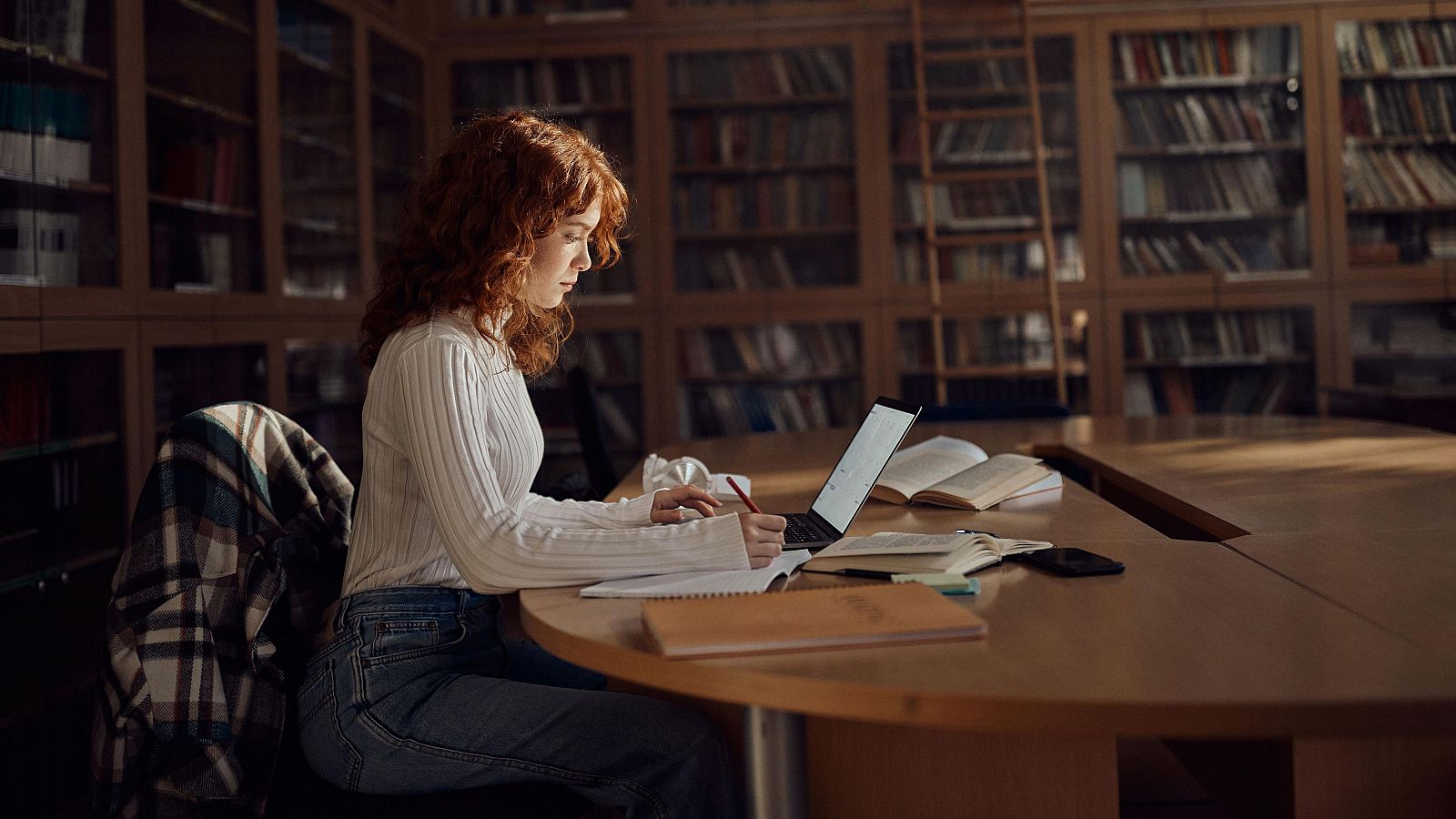 Una chica estudiando en una biblioteca