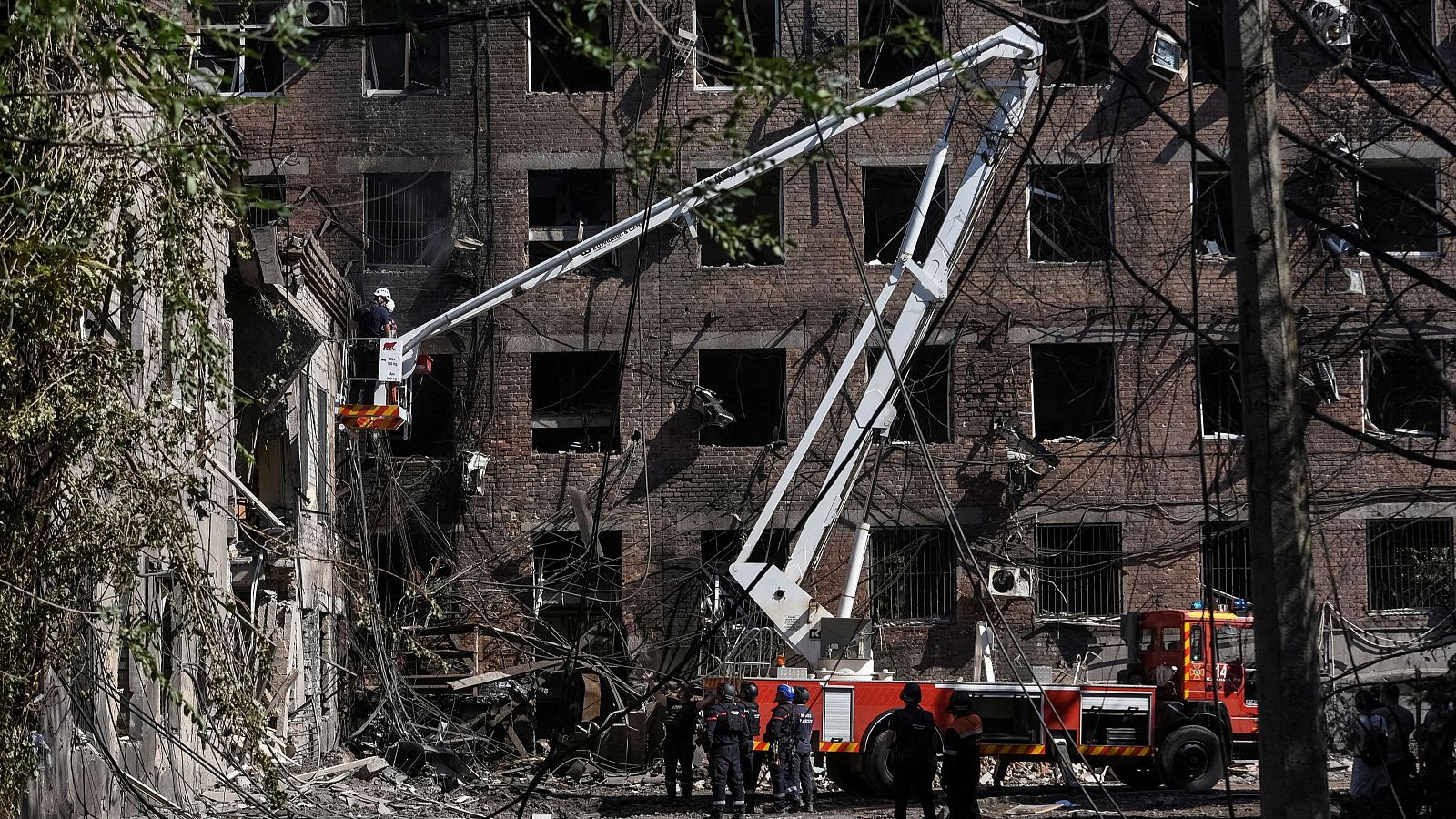 Bomberos ucranianos trabajan en un edificio de apartamentos alcanzado por un ataque con misiles rusos