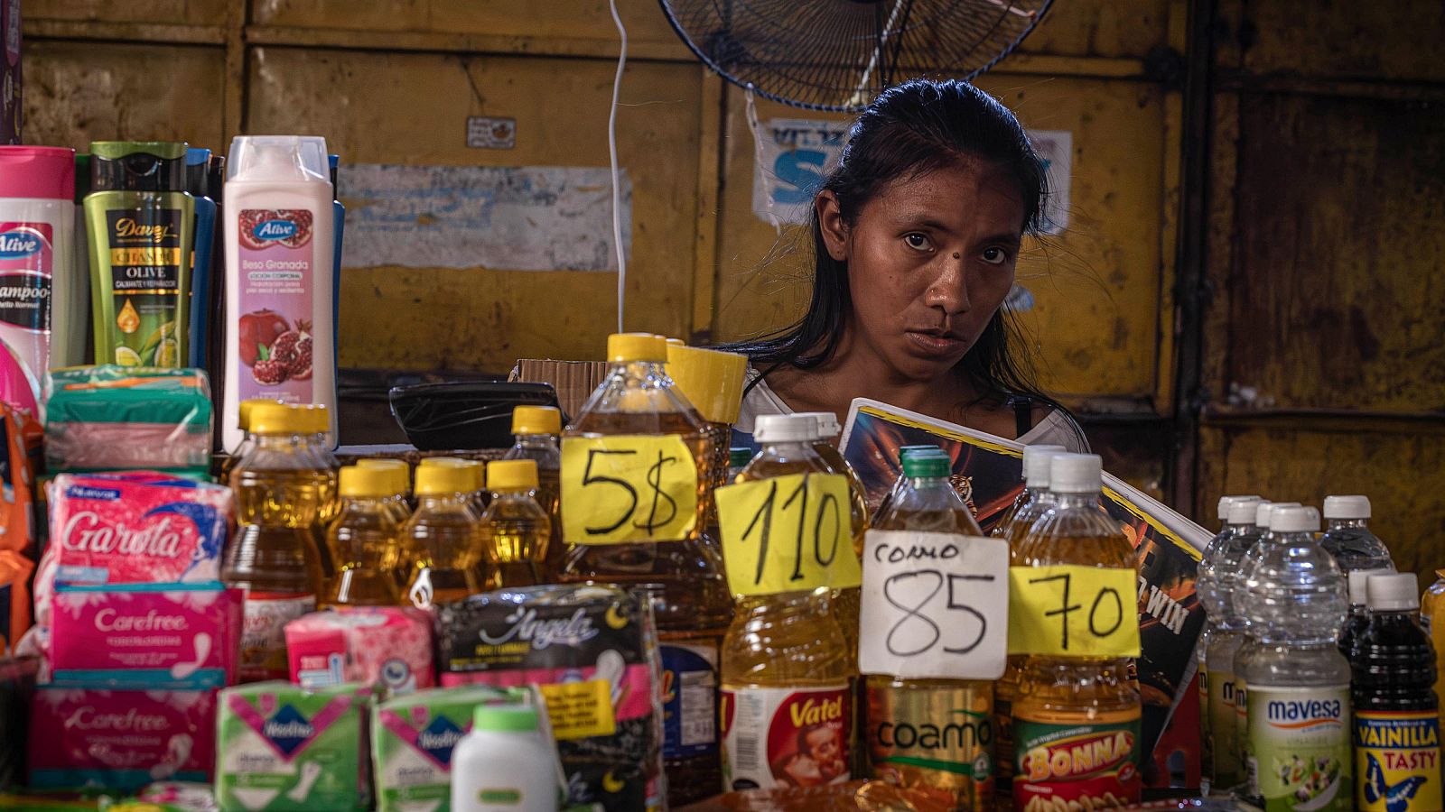 Los expertos analizan la situación económica y sanitaria ante las elecciones presidenciales del día 28. Imagen de archivo de una mujer vendiendo en un mercado popular en Maracaibo (Venezuela).