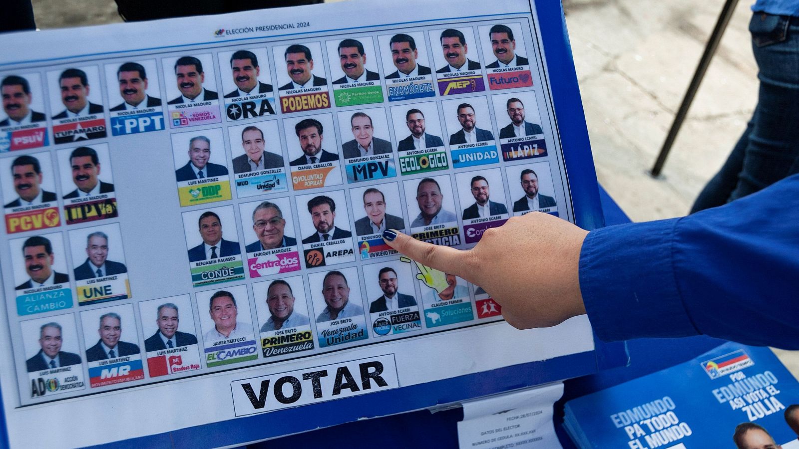 Una persona señala la fotografía de uno de los candidatos a las presidenciales en Venezuela en una papeleta electoral