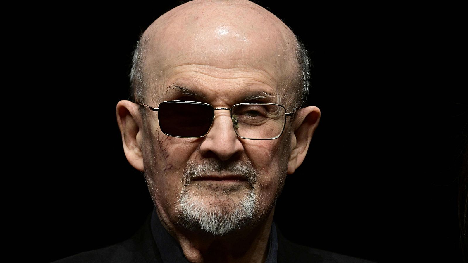 El escritor Salman Rushdie con unas gafas con un cristal negro en el ojo derecho