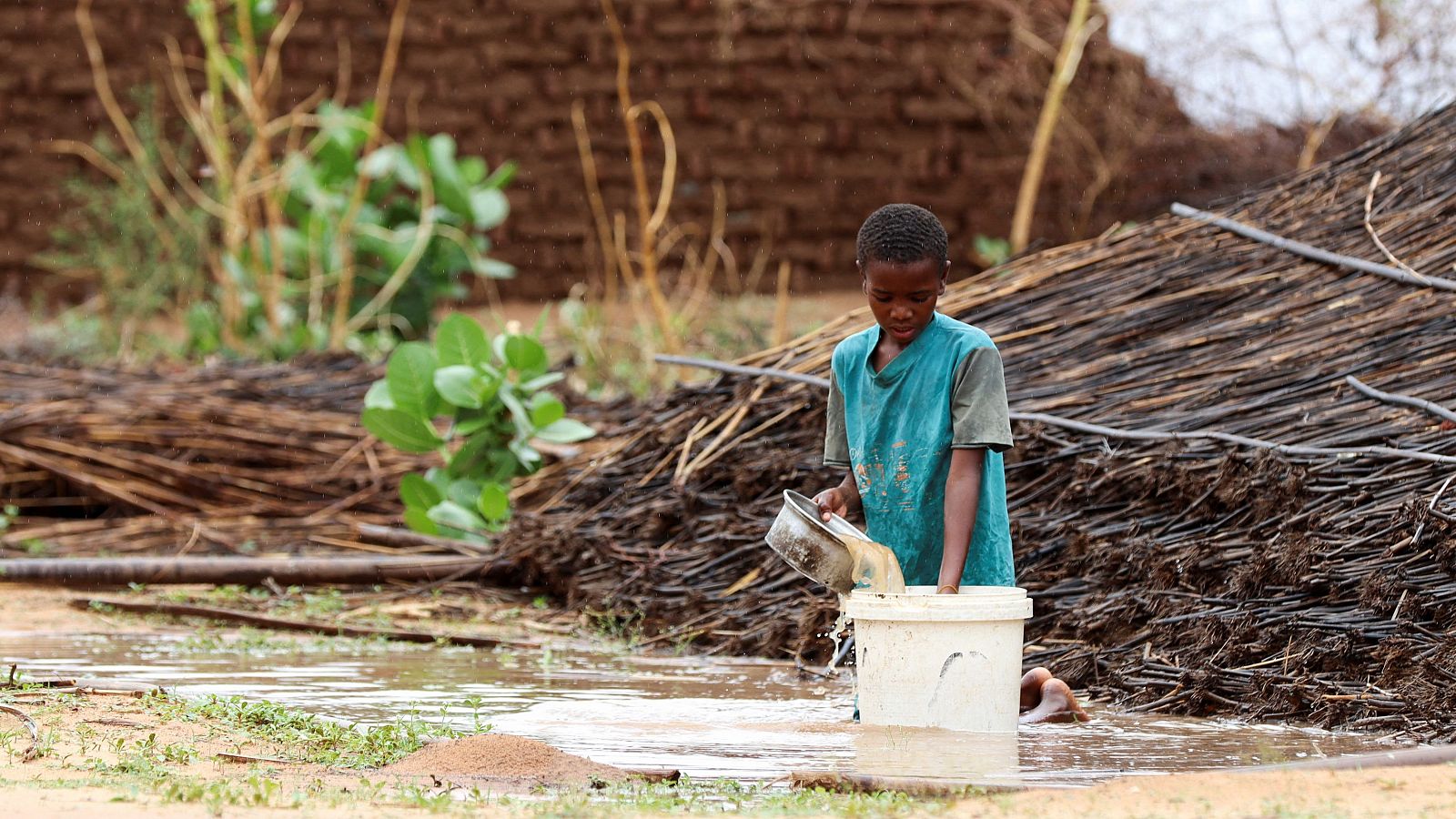 Un niño sudanés desplazado vierte agua en el campamento de Zamzam, en Darfur del Norte, Sudán.