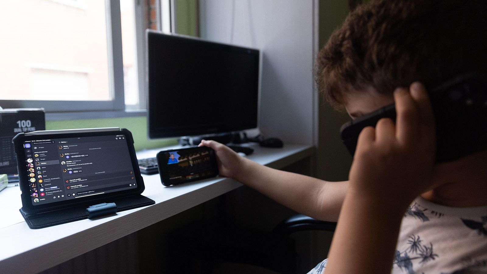 Adolescente usando el teléfono móvil y la tablet