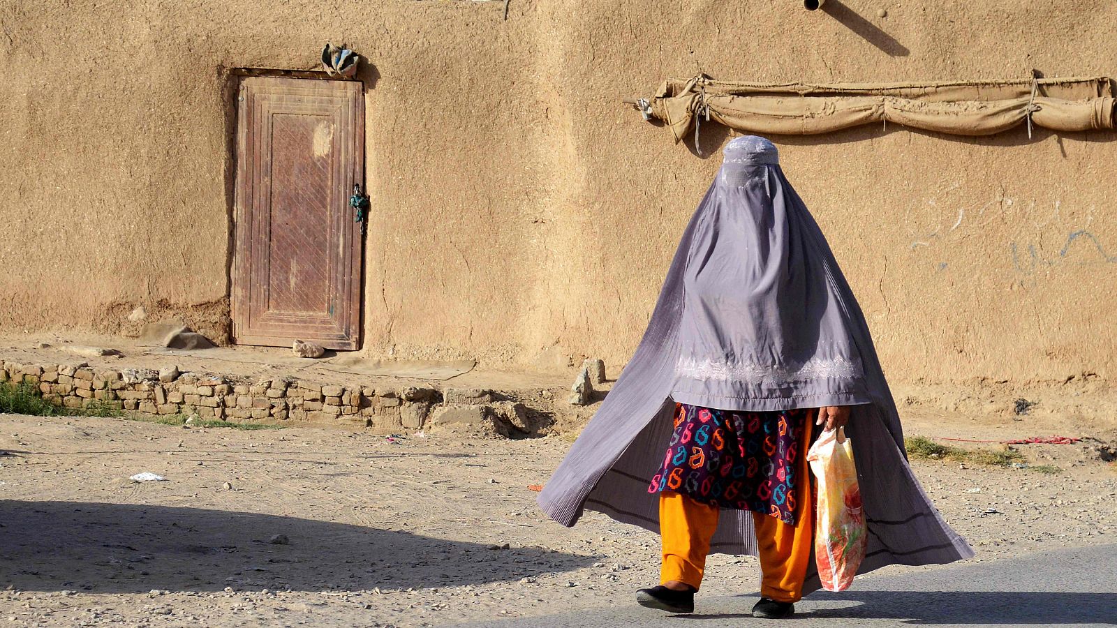 Una mujer afgana camina por una calle de Kandahar, Afganistán